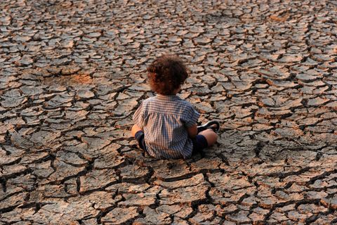 Symbolbild für Klimawandel: Ein Kind sitzt auf ausgedörrter Erde in der Nähe der Stadt Tegucigalpa, der Hauptstadt von Honduras
