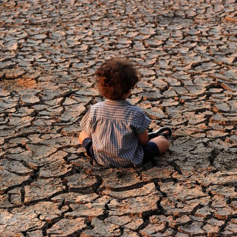 Symbolbild für Klimawandel: Ein Kind sitzt auf ausgedörrter Erde in der Nähe der Stadt Tegucigalpa, der Hauptstadt von Honduras