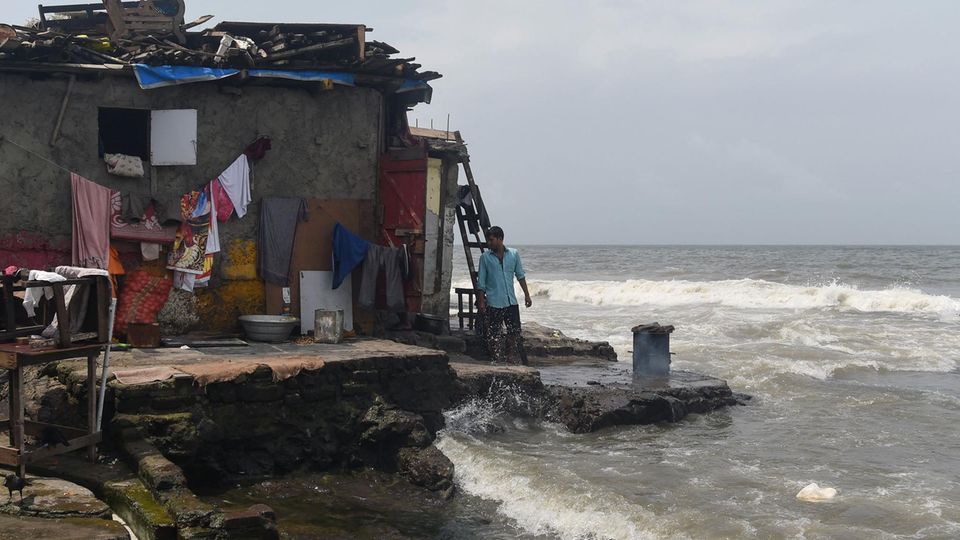 Klimawandel Flut Ein Mann steht im indischen Mumbai vor seinem Haus.