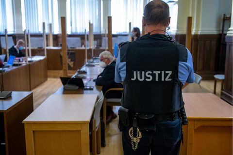 Ein Justizbeamter bewacht die Anklagebank im Landgericht Leipzig.
