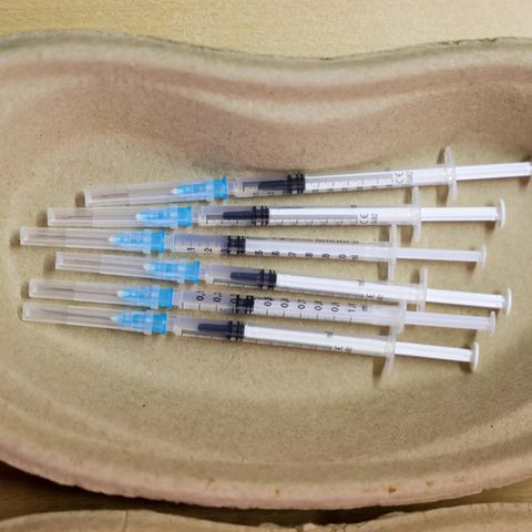 Delta Coronavirus Impfung: Spritzen mit Impfstoff liegen in einer Schaöe