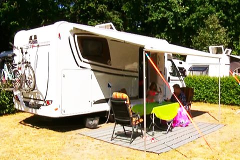 Familie sitzt vor ihrem Campingwagen