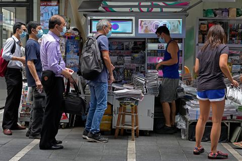 Menschen stehen Schlange vor Kiosk