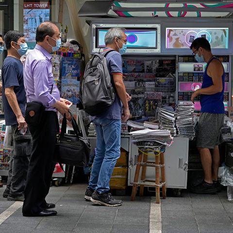 Menschen stehen Schlange vor Kiosk