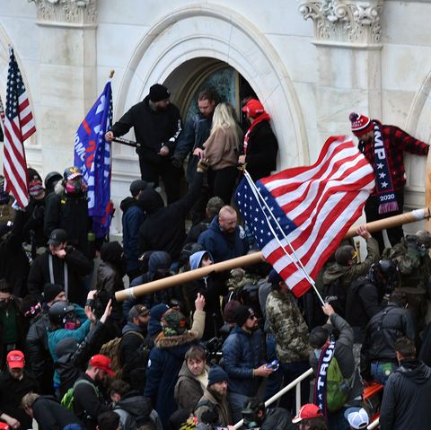 Anhänger des damaligen US-Präsidenten Trump stürmen das US-Kapitolgebäude und schwingen eine USA-Flagge
