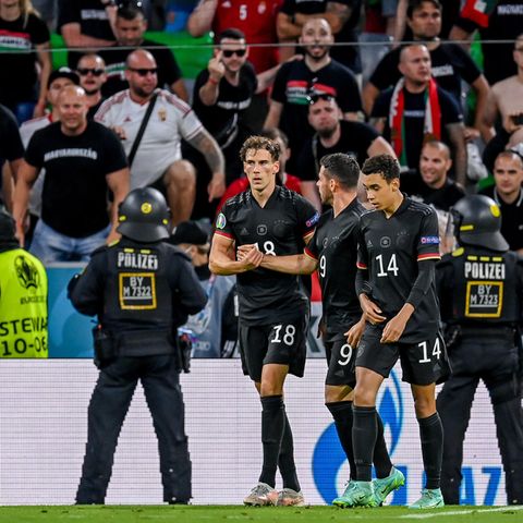 Leon Goretzka (l.), Kevin Volland und Jamal Musiala nach dem Tor zum 2:2, im Hintergrund die als gewaltbereit geltenden Anhänger der sogenannten "Carpathian Brigade" sowie Einsatzkräfte der Polizei