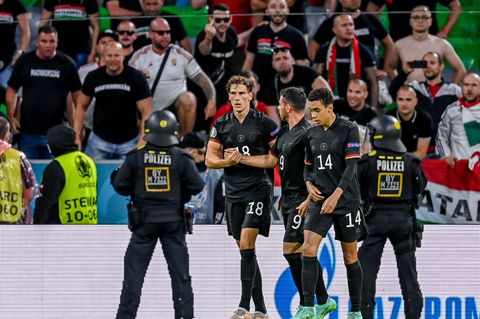 Leon Goretzka (l.), Kevin Volland und Jamal Musiala nach dem Tor zum 2:2, im Hintergrund die als gewaltbereit geltenden Anhänger der sogenannten "Carpathian Brigade" sowie Einsatzkräfte der Polizei