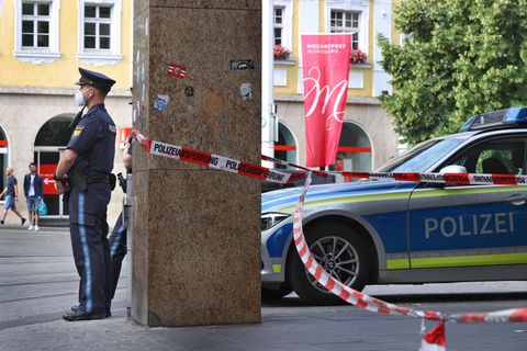 Polizisten stehen vor dem geschlossenen und abgesperrten Geschäft in der Innenstadt von Würzburg