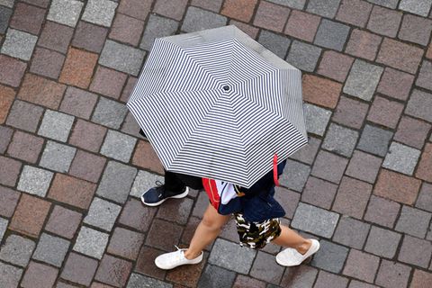 Symbolbild zum Siebenschläfer: Passanten gehen bei Regen in Potsdam spazieren.