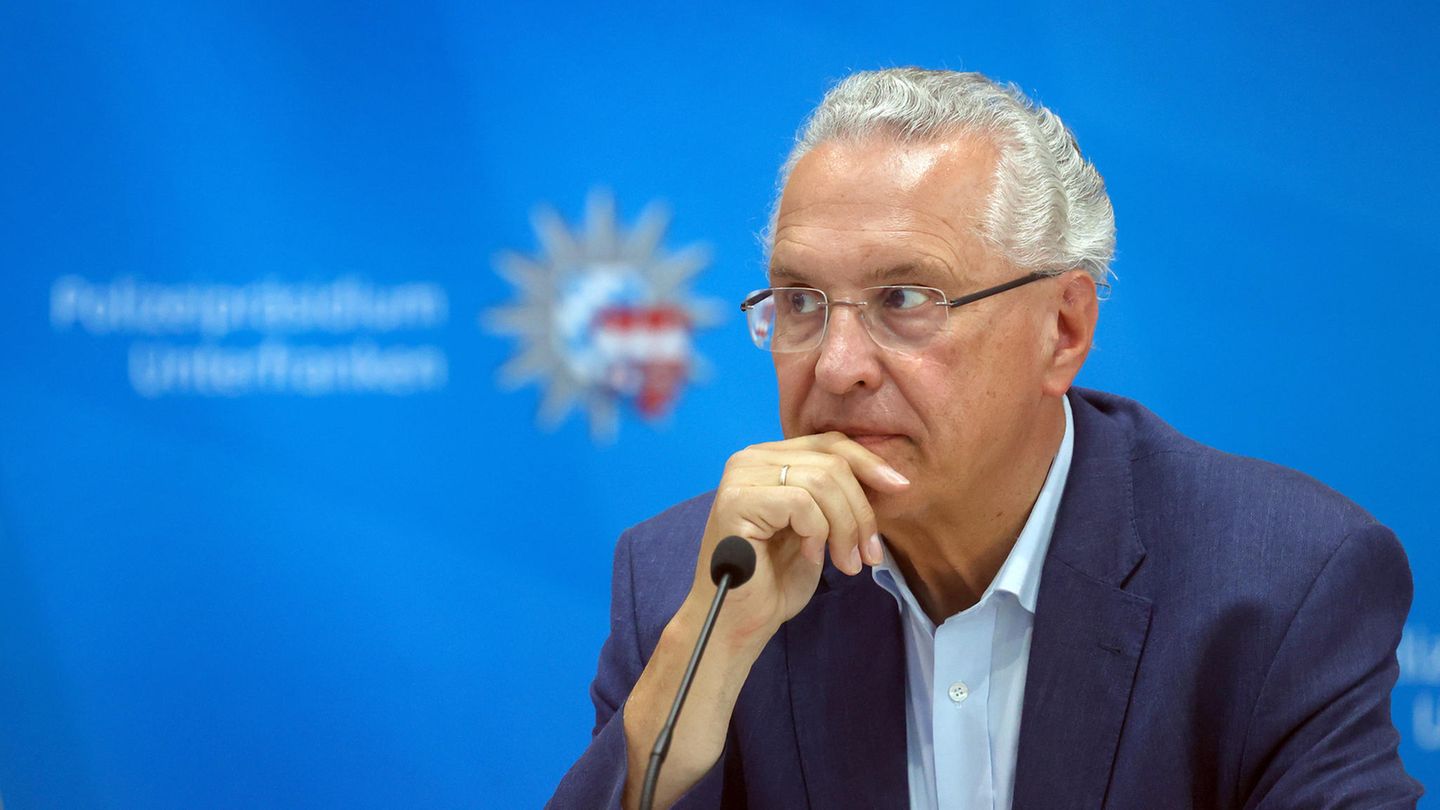 Joachim Herrmann Innenminister Bayern CSU Ein weißer Mann im Anzug und mit Geheimratsecken sowie weißen Locken schaut nachdenklich und hält die rechte Hand ans Kinn