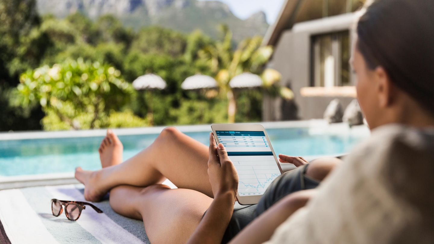 Frau mit Tablet in der Hand am Pool
