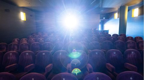 Ein Kinosaal erleuchtet vom Licht des Projektors.