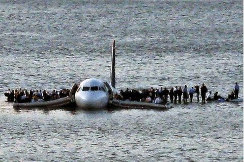 Airline passengers wait to board a ferry to be rescued on the wings of a US Airways Airbus 320 jetliner that safely ditched in the frigid waters of the Hudson River in New York, Thursday Jan. 15, 2009 after a flock of birds knocked out both its engines....