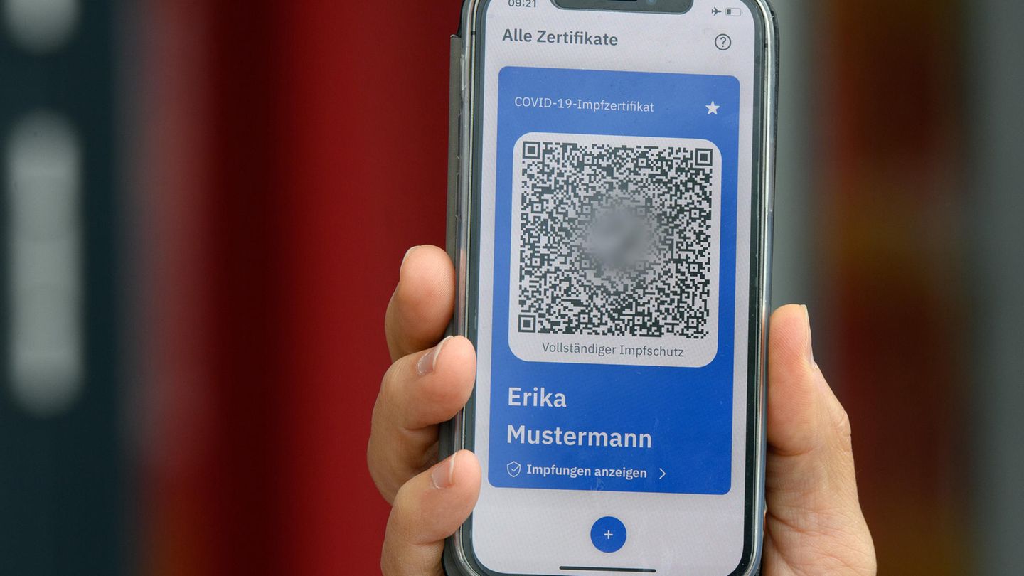 Eine Hand hält ein Mobiltelefon mit einem QR-Code