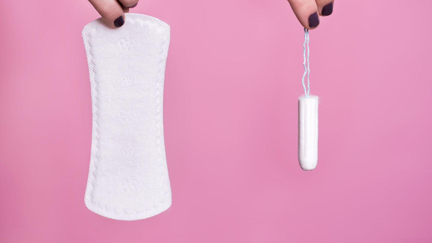 Zwei Hände halten jeweils eine Binde und einen Tampon
