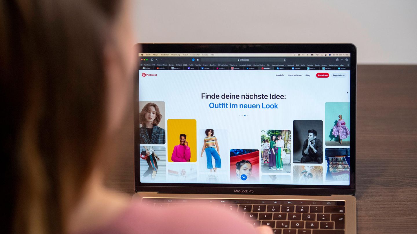 Eine Frau sitzt am Schreibtisch und durchsucht die Plattform Pinterest