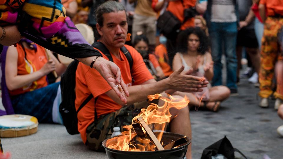 Tabak wird während des Gedenkens für getötete indigene Kin der ins Feuer geworfen