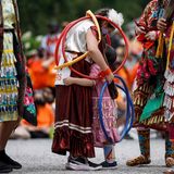 Junge Tänzer umarmen sich, bevor sie mit ihrer Gruppe vor dem Toronto Rathaus tanzen werden