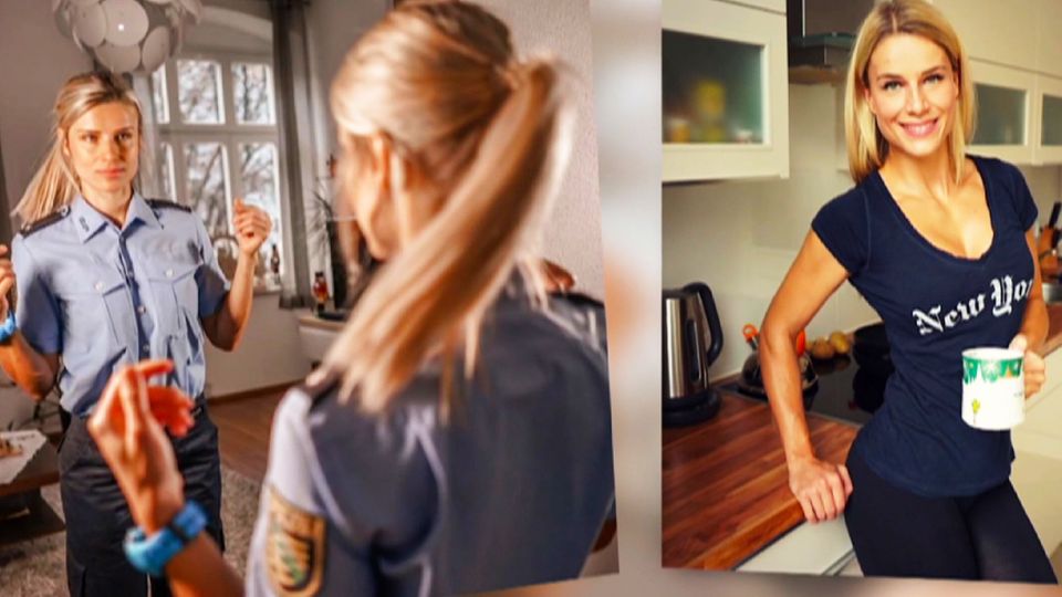 Adrienne Koleszar steht vor dem Spiegel in Polizei-Uniform
