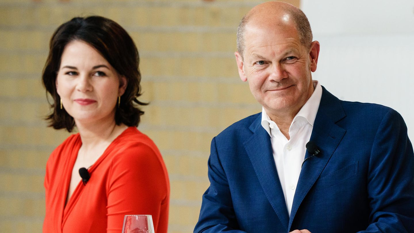 Annalena Baerbock im roten Kleid und Olaf Scholz im blauen Anzug