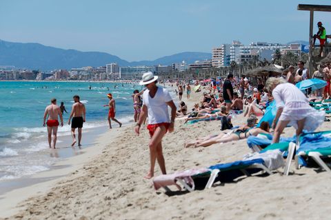 Touristen am Strand von Arenal in Palma de Mallorca