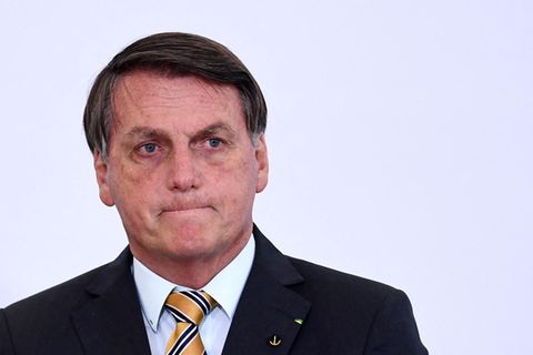 Ein älterer weißer Mann mit dunkelgrauem Seitenscheitel trägt Anzug und schaut mit verkniffenem Mund