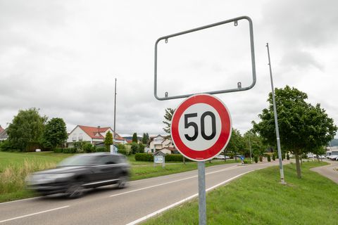 Auto fährt an leerem Ortsschild vorbei