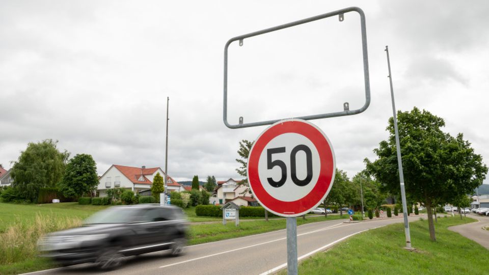 Auto fährt an leerem Ortsschild vorbei
