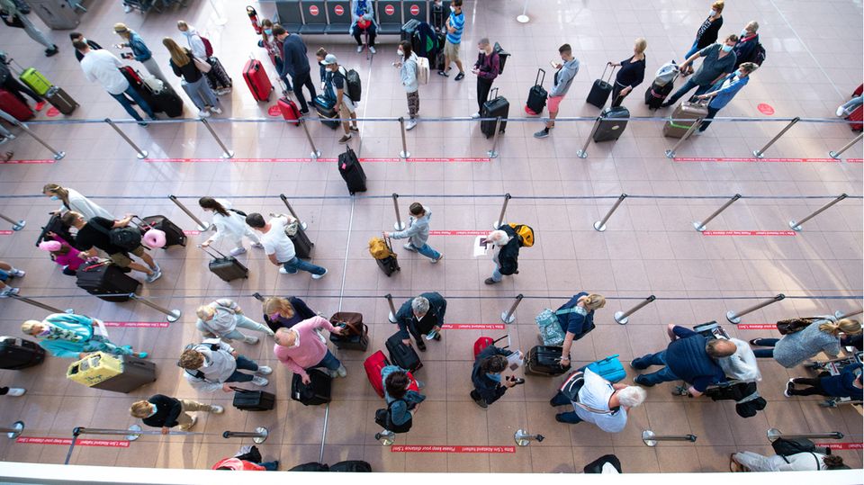 Hamburg: Fluggäste warten in einer langen Schlange vor dem Check-In im Terminal 1