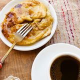 Pita nach Sfakia-Art      Zutaten:  Für den Teig: 500 g Mehl, Salz, 4 EL Olivenöl, 2 EL Raki, 350 g Myzithra (griech. Weichkäse; ersatzweise 250 g Ricotta und 100 g Ziegenfrischkäse)  Außerdem: Mehl zum Arbeiten, Olivenöl zum Frittieren, 6 EL Honig      Zubereitung:  Für den Teig das Mehl in eine Schüssel geben und in die Mitte eine Mulde drücken. 1 Prise Salz, Olivenöl, Raki und 125 ml Wasser hineingießen und alles mit den Händen verkneten, dabei nach und nach so viel Wasser hinzufügen, bis ein geschmeidiger Teig entsteht. Den Teig zu einer Kugel formen und mit einem Teller abgedeckt 20 Min. bei Zimmertemperatur ruhen lassen. Den Teig durchkneten, halbieren und zu zwei Kugeln formen. Die Arbeitsplatte mit Mehl bestäuben und die Teigkugeln darauf nacheinander zu Rechtecken von ca. 50 × 30 cm ausrollen. Die Teigplatten in jeweils sechs Streifen von ca. 8 × 30 cm schneiden. Den Käse in einer Schüssel verrühren und auf dem Teig verteilen. Die Teigstreifen von den Längsseiten her aufrollen. Die Rollen zu Schnecken oder Kreisen formen und die Enden gut andrücken. In einer Pfanne ca. 4 cm hoch Olivenöl erhitzen und die Sfakiopitas darin nacheinander goldgelb frittieren, dabei zwischendurch wenden. Auf Küchenpapier abtropfen lassen und noch warm mit Honig beträufelt servieren. Dazu passt ein starker Mokka.