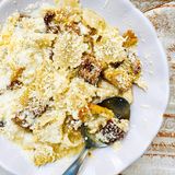 Nudeln auf kretische Art      Zutaten:   Für den Teig: 400 g Mehl, Salz, 4 EL Olivenöl  Außerdem: Mehl zum Arbeiten, Salz, 8 EL Olivenöl zum Braten, 300 g Hartkäse (z. B. Kefalotyri; ersatzweise Pecorino oder Parmesan)      Zubereitung:  Das Mehl in einer großen Schüssel mit 1 Prise Salz mischen. In die Mitte eine Mulde drücken, das Olivenöl und 100 ml Wasser hineingießen. Alles mit den Händen zu einem glatten Teig verkneten, dabei nach und nach ca. 100 ml Wasser hinzufügen. Den Teig zu einer Kugel formen und mit Frischhaltefolie bedeckt ca. 20 Min. ruhen lassen. Die Arbeitsplatte mit etwas Mehl bestreuen. Den Teig halbieren und die Hälften nacheinander in ca. 2 mm dünne Rechtecke ausrollen. Die Teigplatten mit einem scharfen Messer oder einem Teigrädchen zuerst längs, dann quer in ca. 2,5 cm breite Streifen schneiden, sodass 2,5 × 2,5 cm große Quadrate entstehen. Die Nudeln mit etwas Mehl bestreuen und, falls nötig, in Form zupfen, damit sie nicht zusammenkleben. In einem großen Topf reichlich Salzwasser zum Kochen bringen. Das Olivenöl in einer Pfanne erhitzen. Eine Hälfte der Nudeln im Salzwasser in ca. 3 Min. sehr bissfest kochen. Die restliche Hälfte im Öl goldbraun braten, dabei zwischendurch wenden. Die gekochten Nudeln in ein Sieb abgießen, dabei ca. 100 ml Kochwasser auffangen. Die Nudeln mit dem Kochwasser zu den gebratenen Nudeln geben und alles 3–4 Min. köcheln lassen. Den Käse fein reiben. Die Magiri in tiefe Teller verteilen, etwas Sud darübergießen und mit Käse bestreuen.