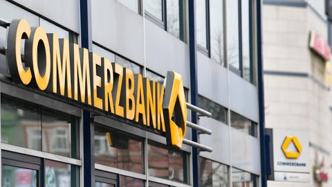Der gelbe Schriftzug "Commerzbank" an der Außenfassade einer Bankfiliale