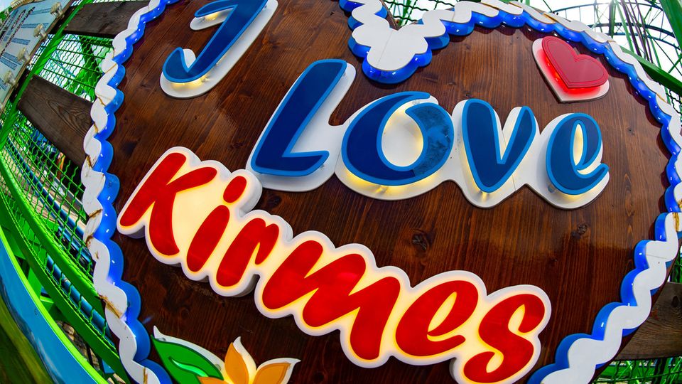 Ein Herz mit dem Schriftzug "I love Kirmes" an einer Achterbahn
