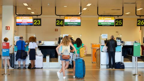 Reisende am Schalter der Fluggesellschaften Lufthansa und Swiss in Faro.