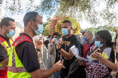 Menschen mit Mund-Nasen-Bedeckung stehen in Lissabon Schlange vor einem Corona-Impfzentrum auf dem Universitätsgelände