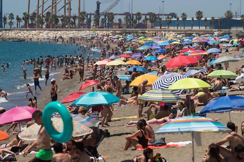 Menschen verbringen in Malaga Zeit am Strand Malagueta an einem heißen Sommertag
