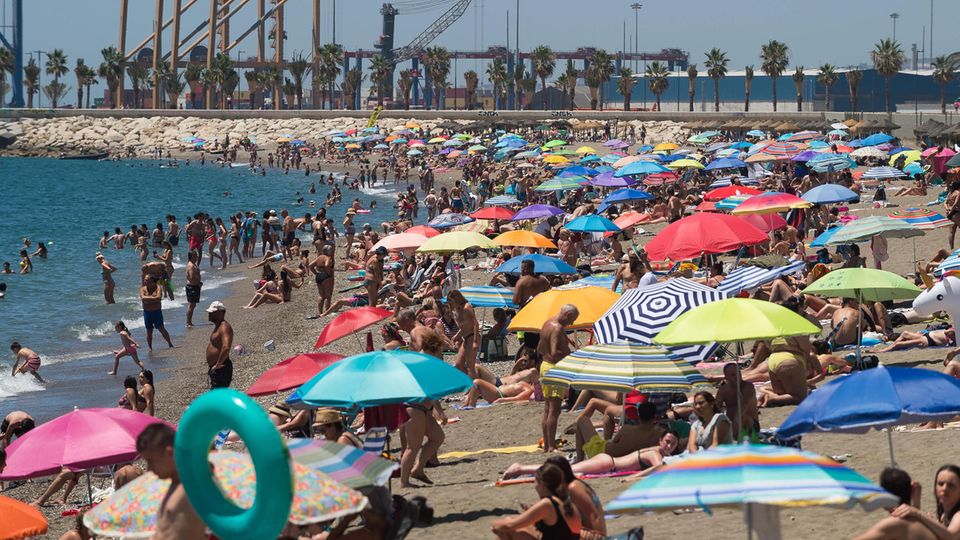 Menschen verbringen in Malaga Zeit am Strand Malagueta an einem heißen Sommertag