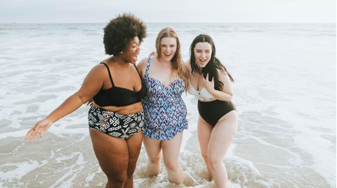 Drei Frauen sind in Badekleidung am Strand