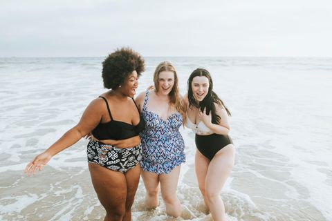 Drei Frauen sind in Badekleidung am Strand