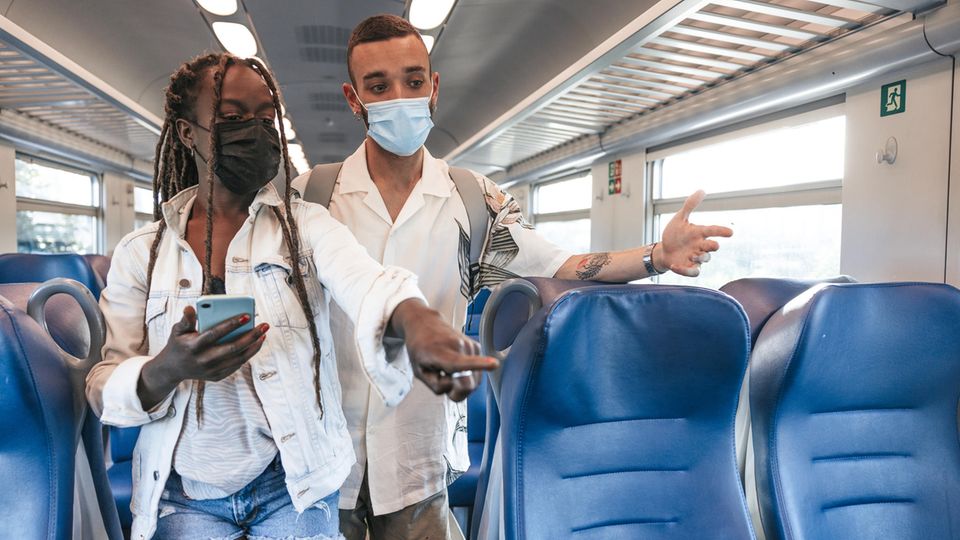 Zwei Menschen suchen im Zug nach einem Platz