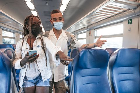 Zwei Menschen suchen im Zug nach einem Platz