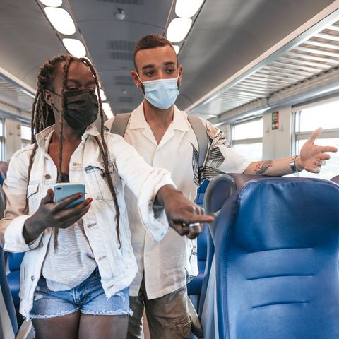 Zwei Menschen suchen im Zug nach einem Platz