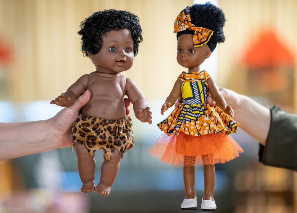 Die Puppe links im Bild hat schwarze Haut und trägt nichts als einen Lendenschurz