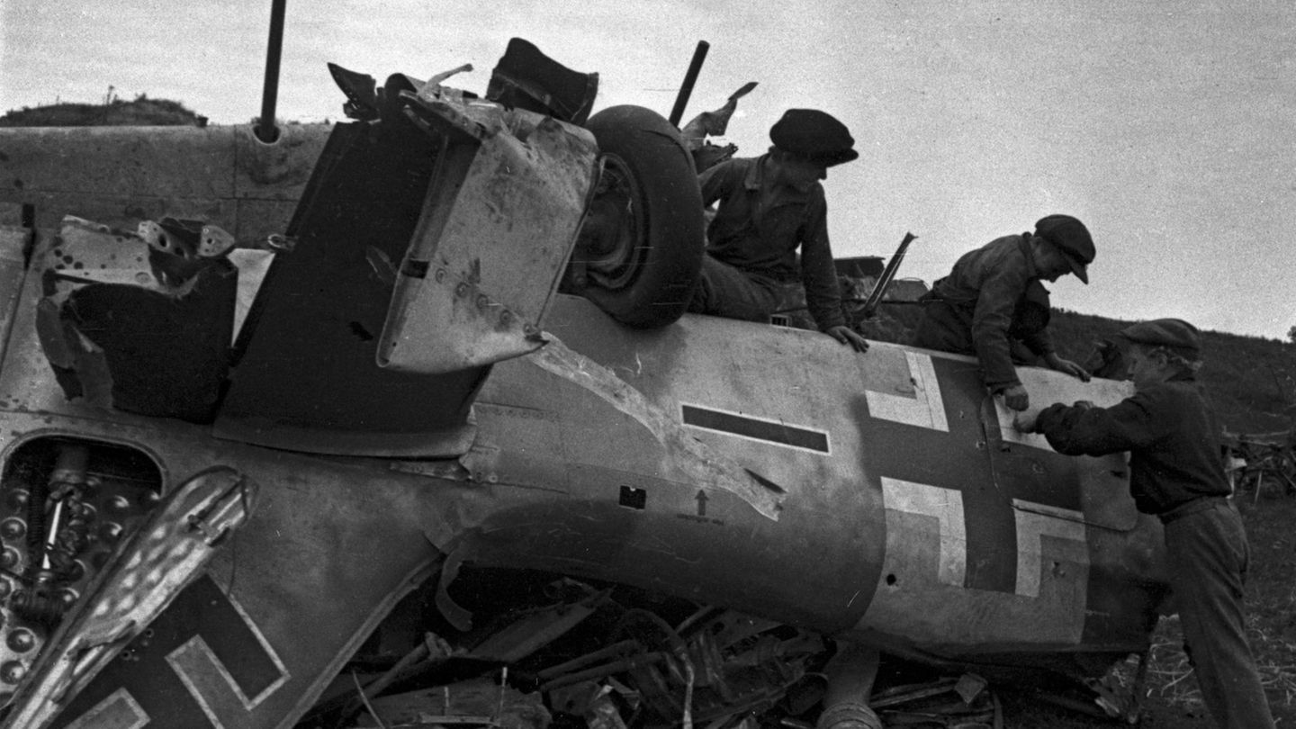Das Wrack einer deutschen Maschine wird von Sowjets untersucht.