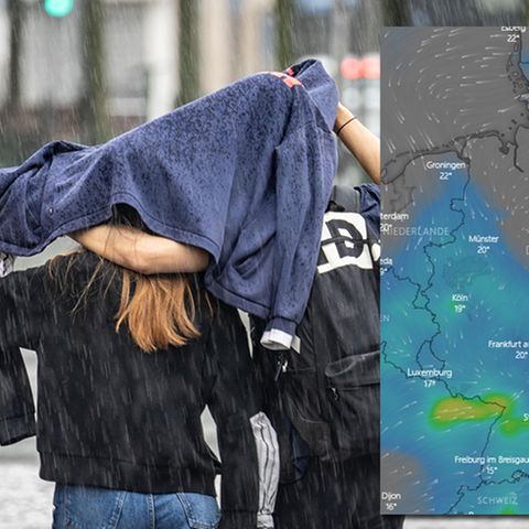 Zwei Passanten versuchen, sich unter einem Pullover vor dem Regen zu schützen.