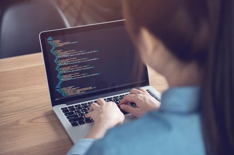 Eine Programmiererin arbeitet an einem Linux-Laptop