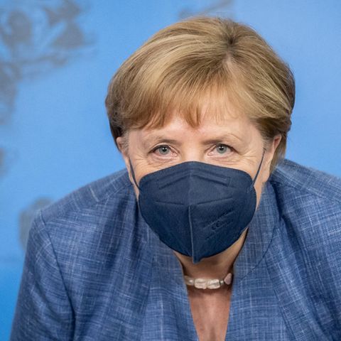 Angela Merkel trägt einen dunkelblauen Mund-Nasen-Schutz