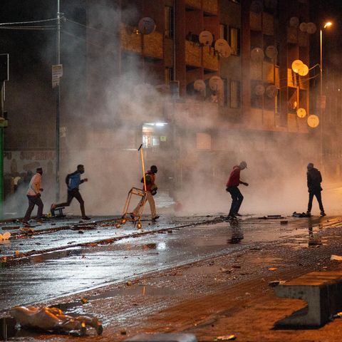 Südafrika, Johannesburg: Demonstranten laufen weg nachdem die Polizei Tränengaskanistern eingesetzt hat