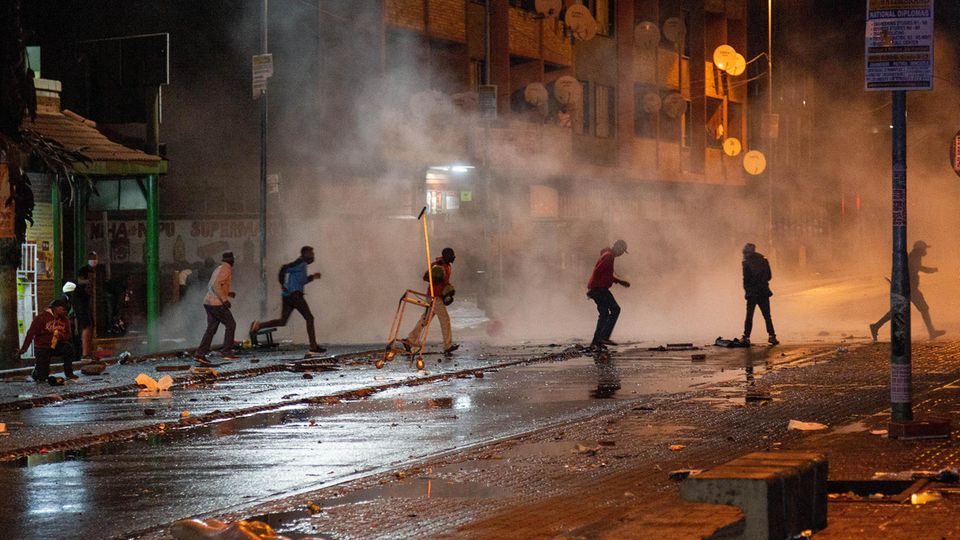 Südafrika, Johannesburg: Demonstranten laufen weg nachdem die Polizei Tränengaskanistern eingesetzt hat