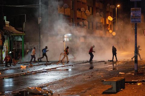 Südafrika, Johannesburg: Demonstranten laufen weg nachdem die Polizei Tränengaskanistern eingesetzt hat